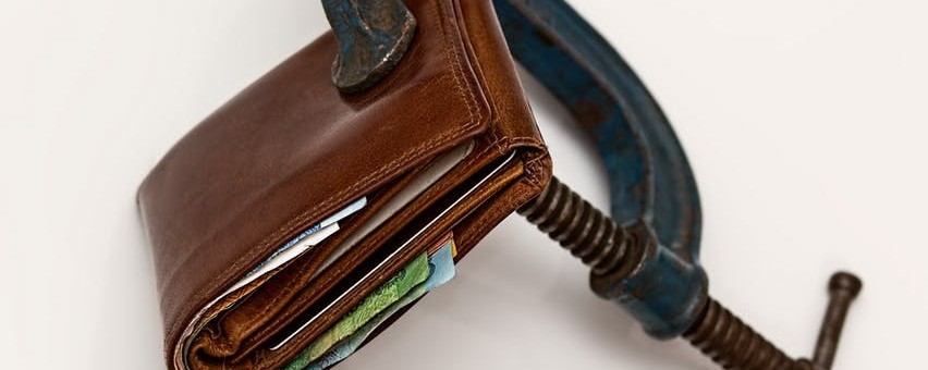 Wallet in vise, demonstrating a budget when buying a massage chair